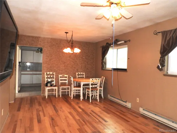 a dining room with furniture a chandelier and wooden floor