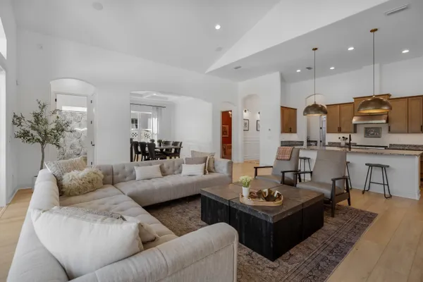 a kitchen with stainless steel appliances granite countertop a sink a stove and a wooden floor