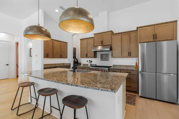 a kitchen with stainless steel appliances granite countertop a sink stove and cabinets