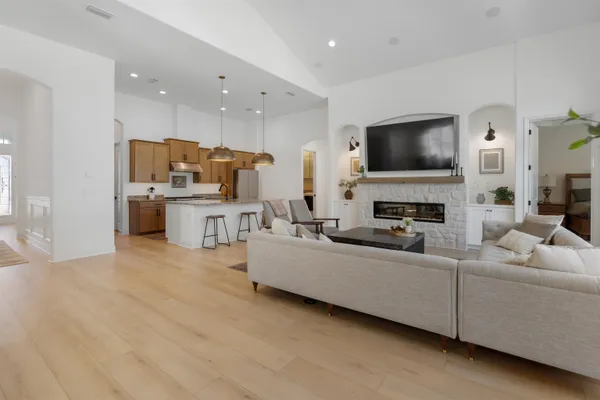 a living room with furniture kitchen view and a chandelier