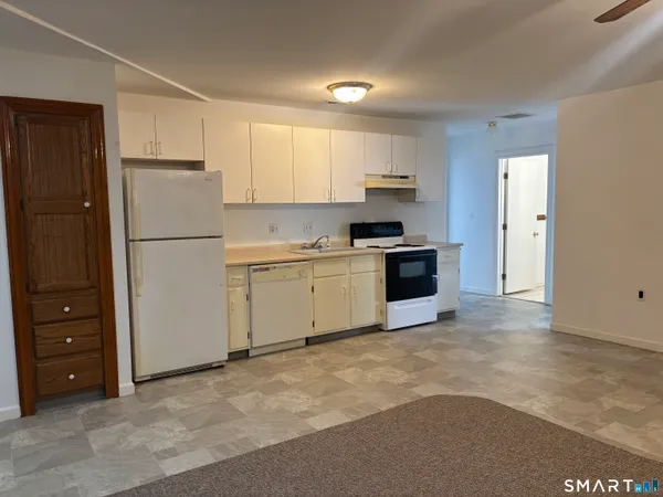 a kitchen with a refrigerator and a stove top oven