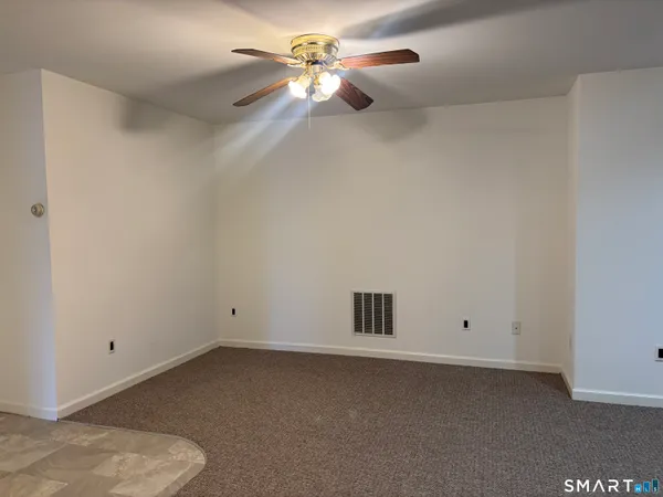 an empty room with a ceiling fan and a window