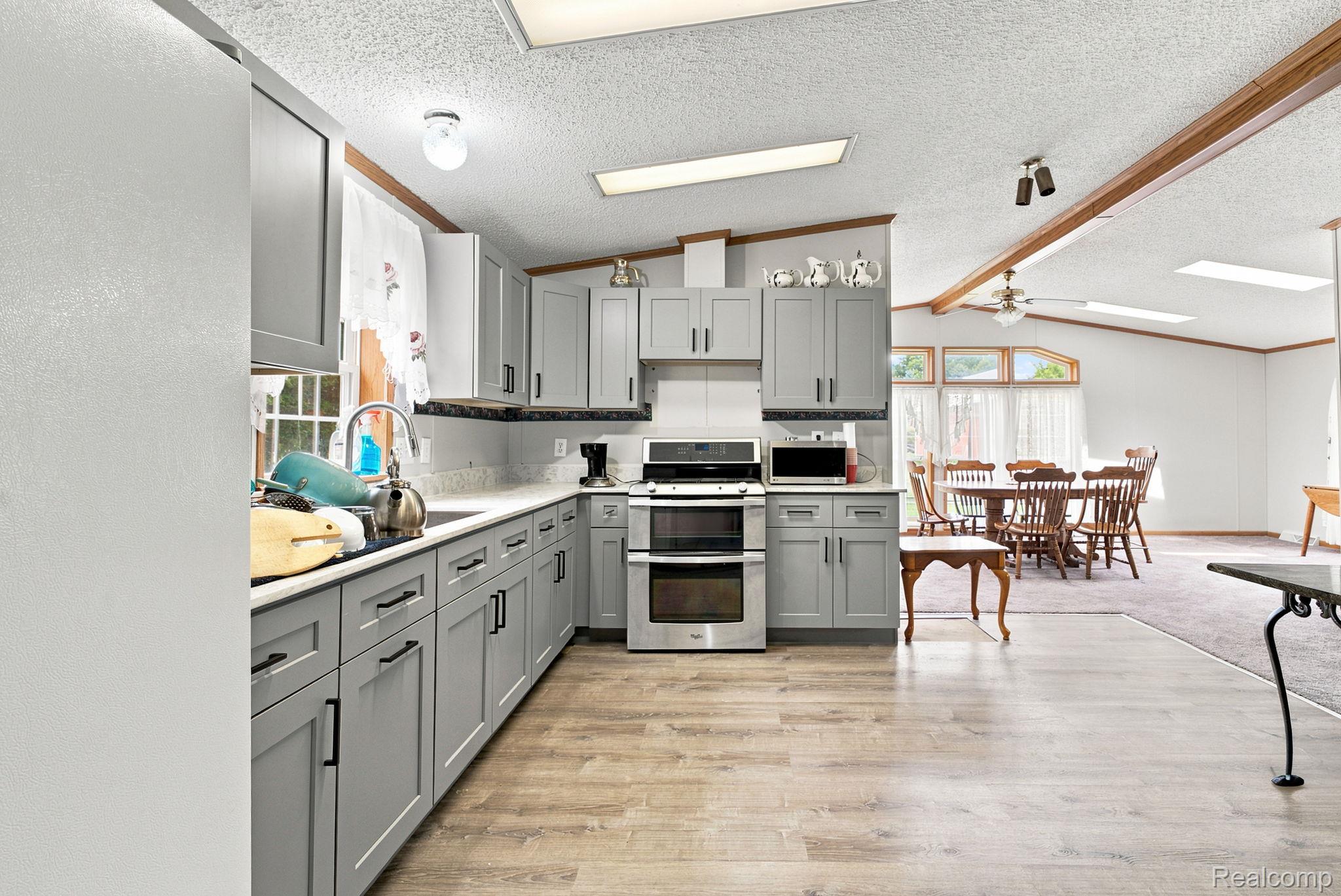 2390 Lakeshore Road Applegate, MI 48401 - Photo 17 of 97 Kitchen featuring gray cabinetry, light-toned countertops, and wood-finish flooring