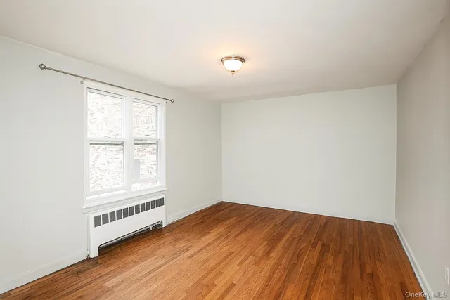 a view of a room with wooden floor and white walls