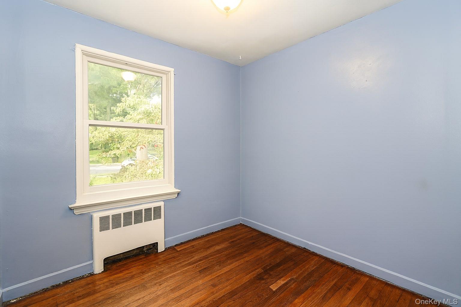 10 Glen Keith Road, Unit U Glen Cove, NY 11542 - Photo 15 of 22 a view of an empty room with wooden floor and a window