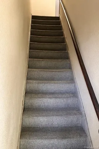 a view of a white house with a yard and potted plants