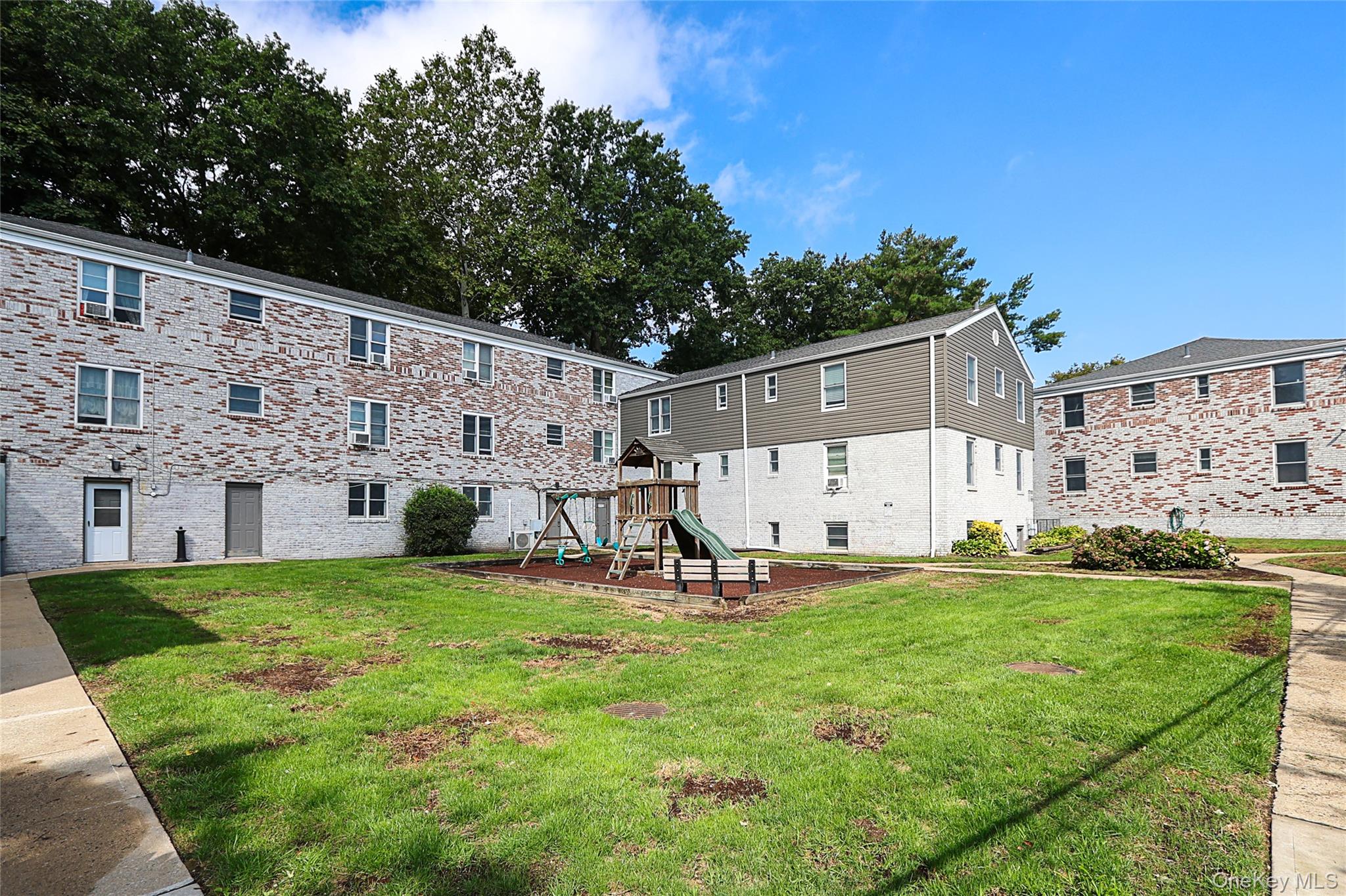 10 Glen Keith Road, Unit U Glen Cove, NY 11542 - Photo 20 of 22 a view of a chair and table and garden in the back yard