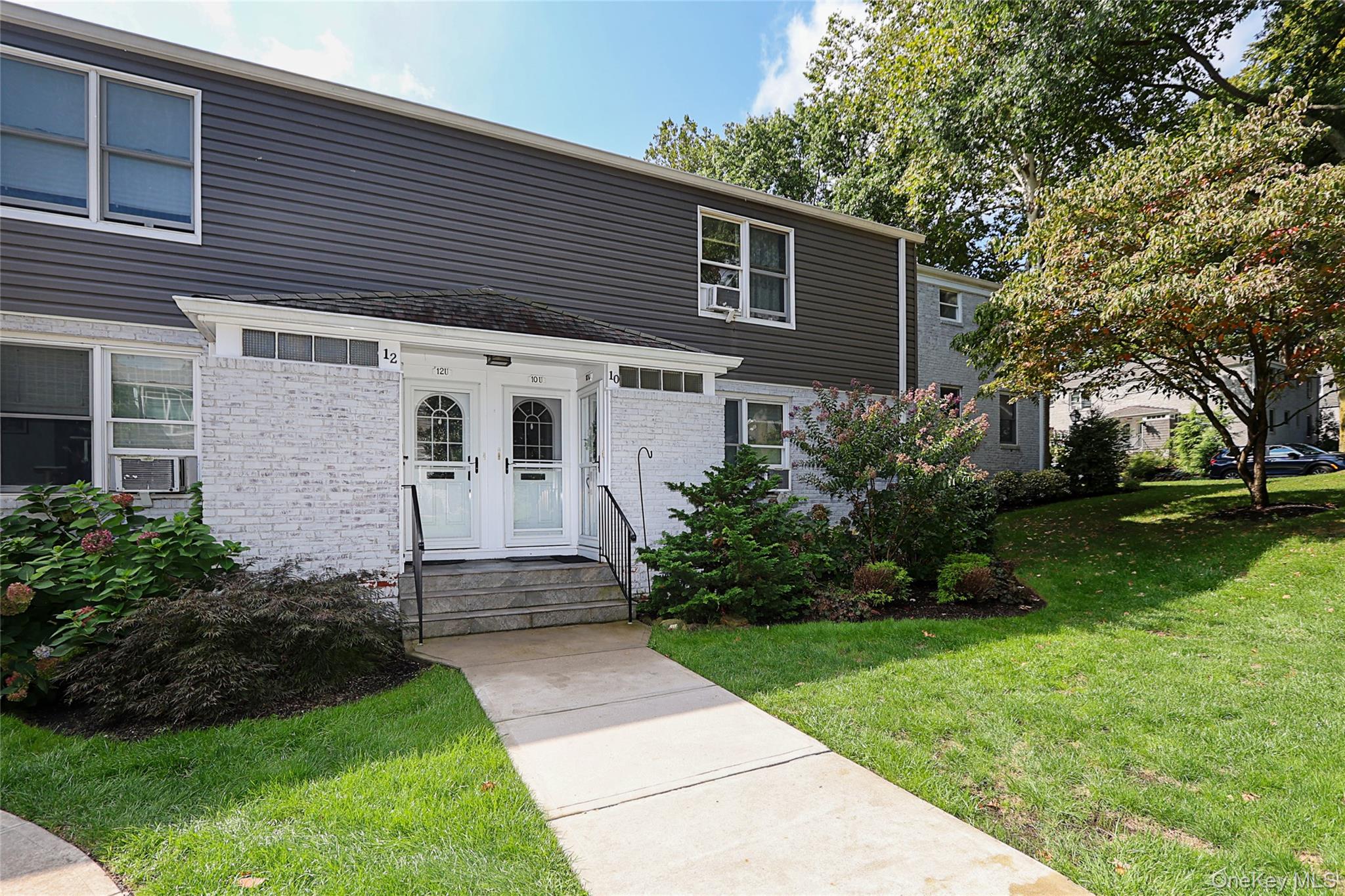 10 Glen Keith Road, Unit U Glen Cove, NY 11542 - Photo 2 of 22 a front view of a house with garden