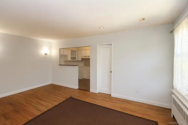 a view of a room with wooden floor and entryway