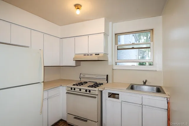 a kitchen with stainless steel appliances white cabinets and a stove top oven