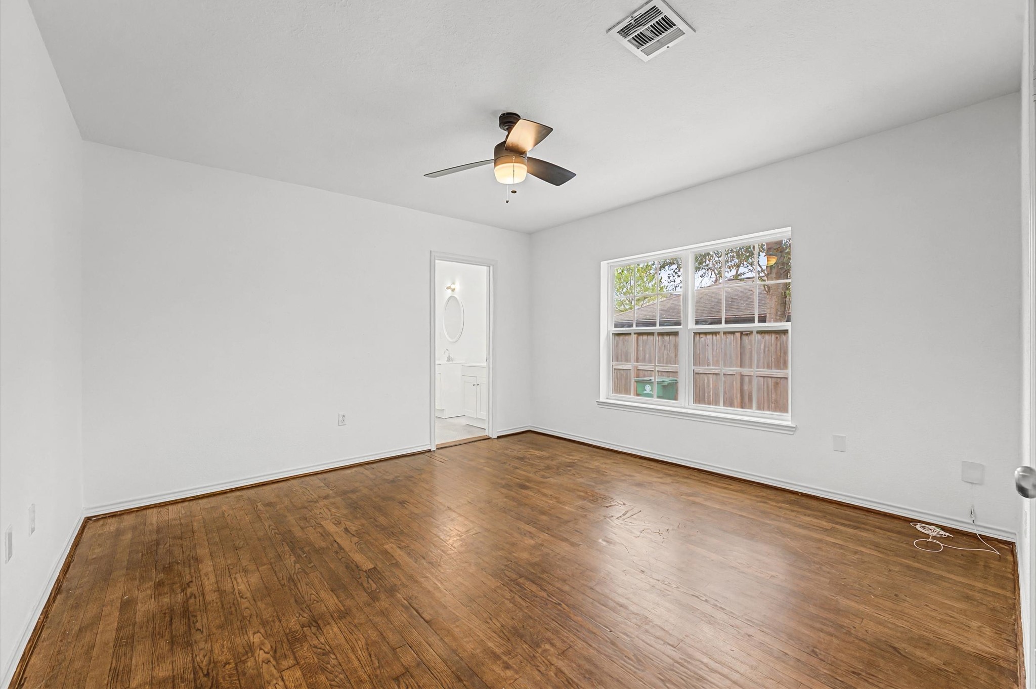 511 Joyce Street Houston, TX 77009 - Photo 11 of 17 an empty room with wooden floor ceiling fan and windows