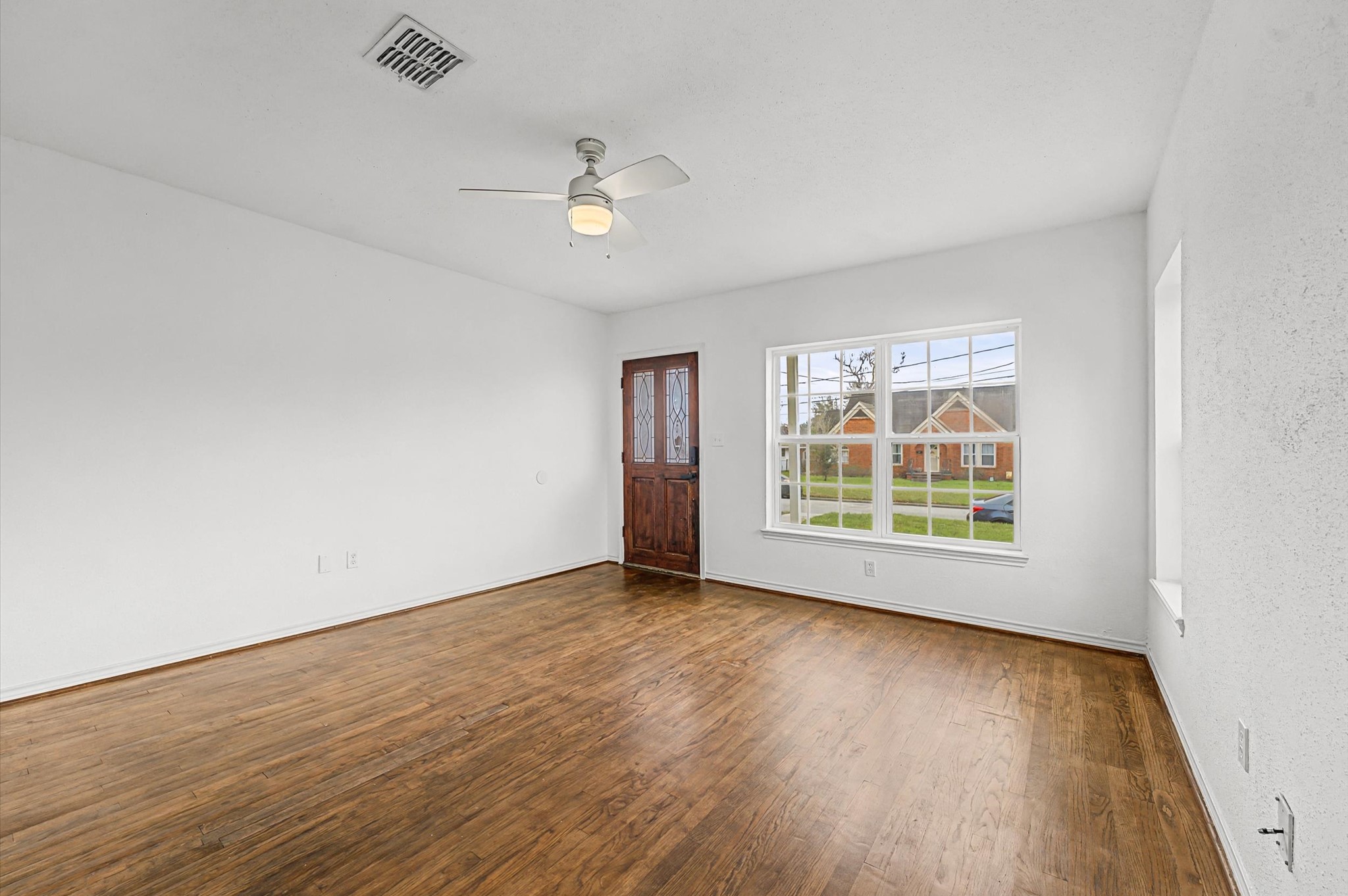 511 Joyce Street Houston, TX 77009 - Photo 4 of 17 an empty room with wooden floor and windows