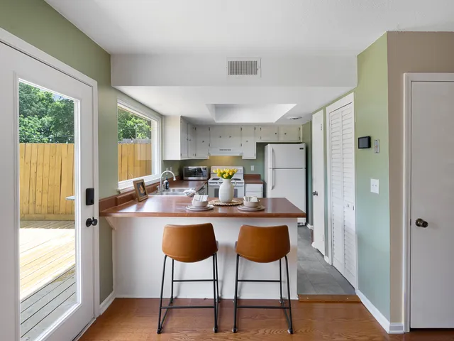 a kitchen with a stove a refrigerator and white cabinets
