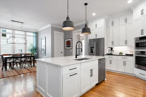 a kitchen with a center island appliances and a dining table