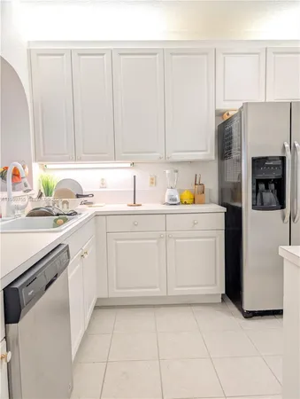 a kitchen with a sink a refrigerator and cabinets