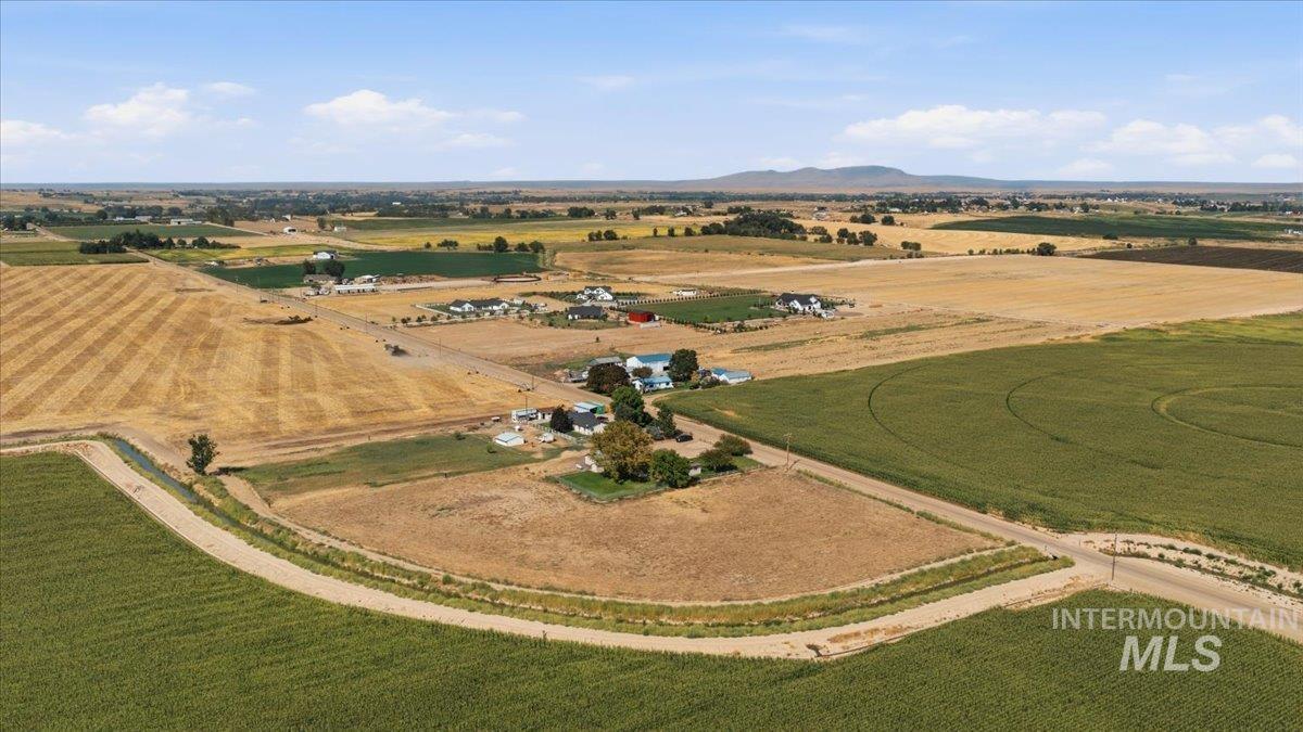 26201 Hop Road Caldwell, ID 83607 - Photo 39 of 45 Expansive agricultural property featuring cultivated fields, a cluster of residential structures, and established trees