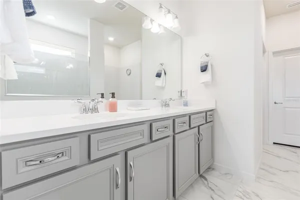 a bathroom with a sink double vanity and a mirror