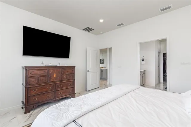 a bedroom with a bed and a flat screen tv