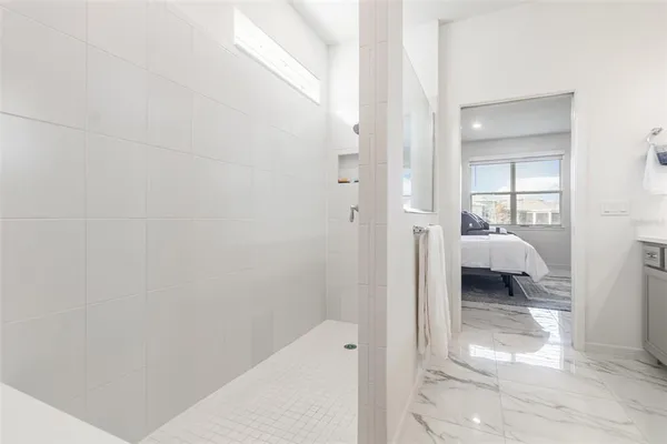 a walk in closet with view of bedroom