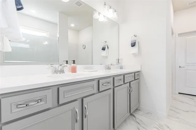 a bathroom with a sink double vanity and a mirror