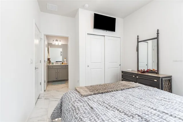 a bedroom with a bed and a flat screen tv