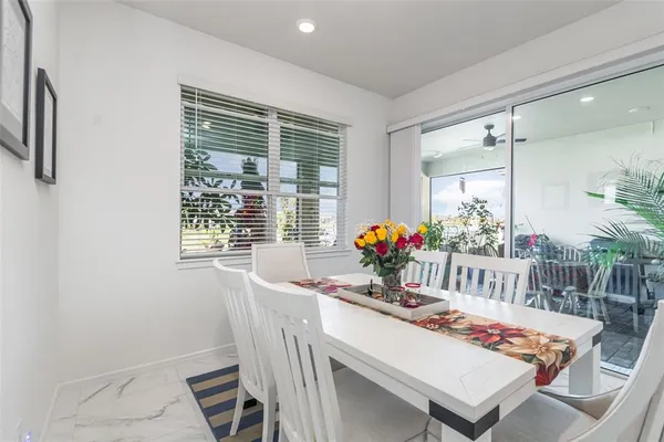 a dining room with furniture and a potted plant