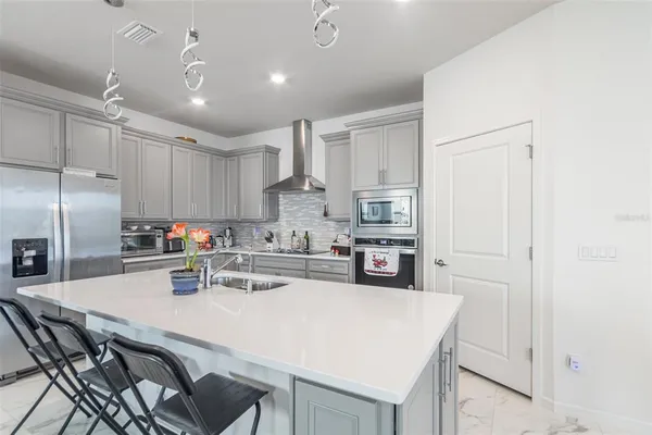 a kitchen with kitchen island a stove a table and chairs in it