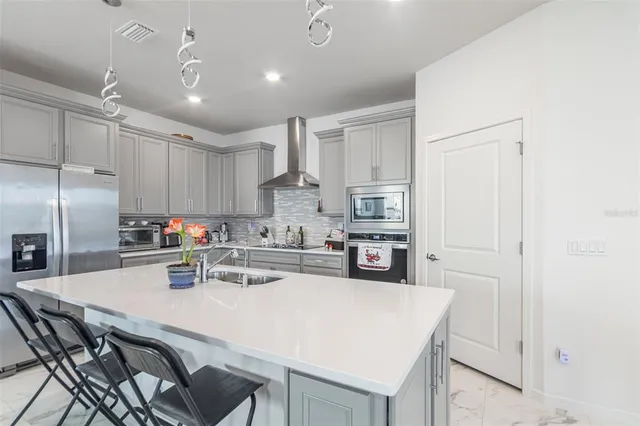 a kitchen with kitchen island a stove a table and chairs in it