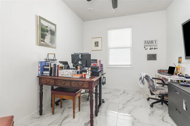 a view of a workspace with furniture and a window