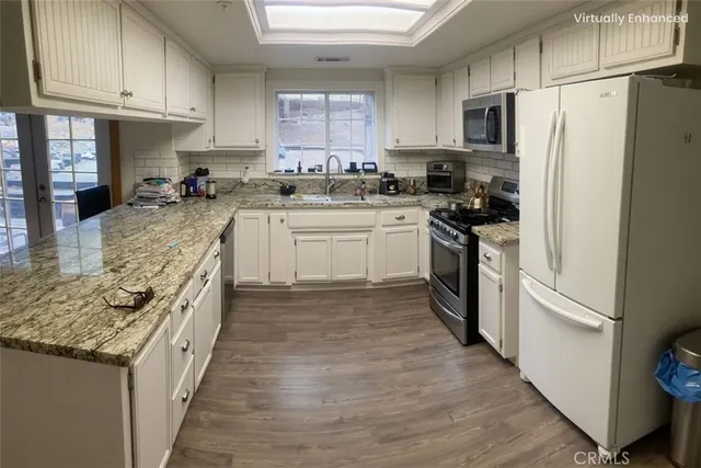 a kitchen with white cabinets and stainless steel appliances