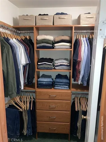a view of walk in closet with clothes and shoes