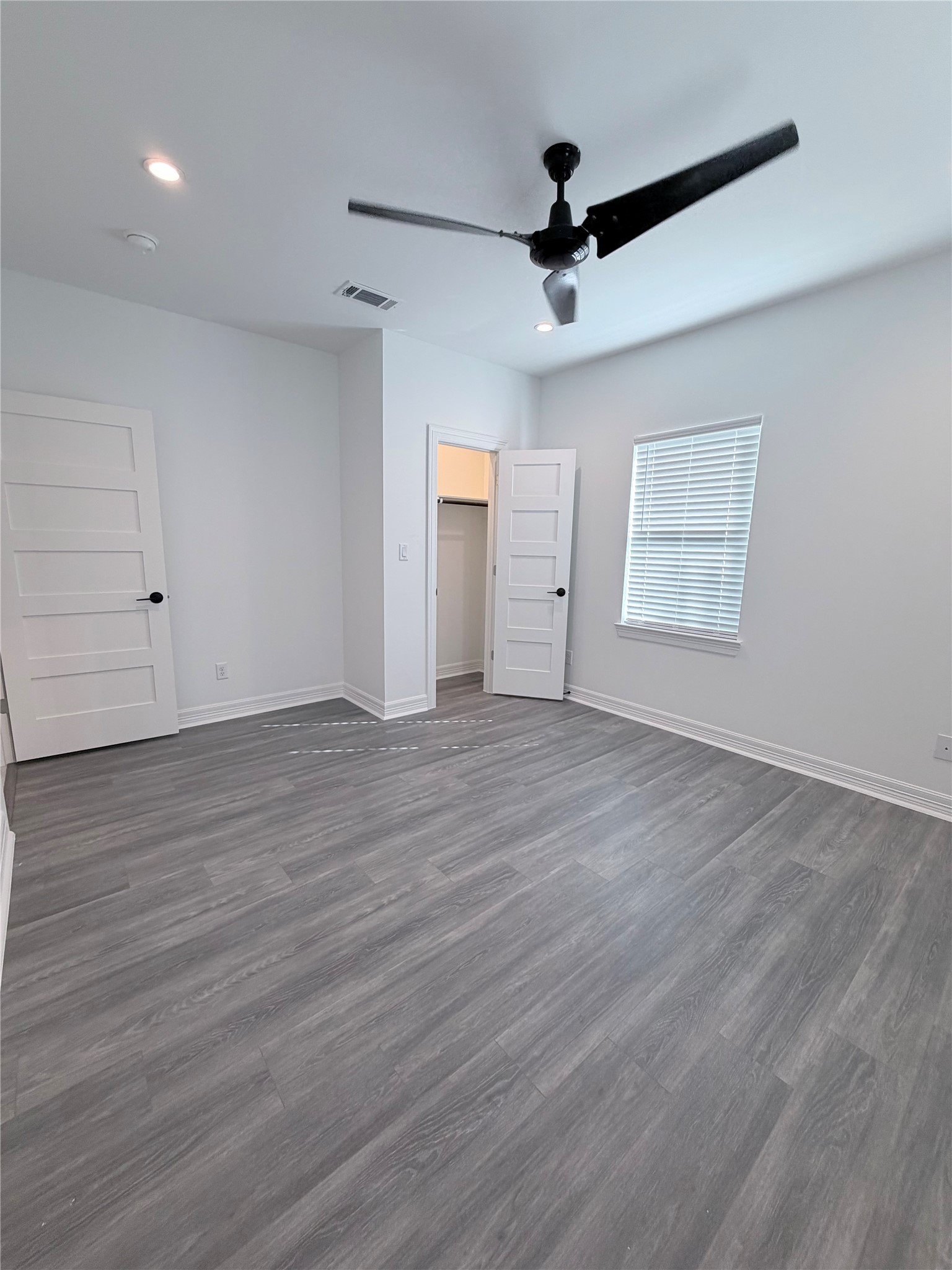 4501 Hirsch Road Houston, TX 77026 - Photo 18 of 30 a view of an empty room with wooden floor and a ceiling fan