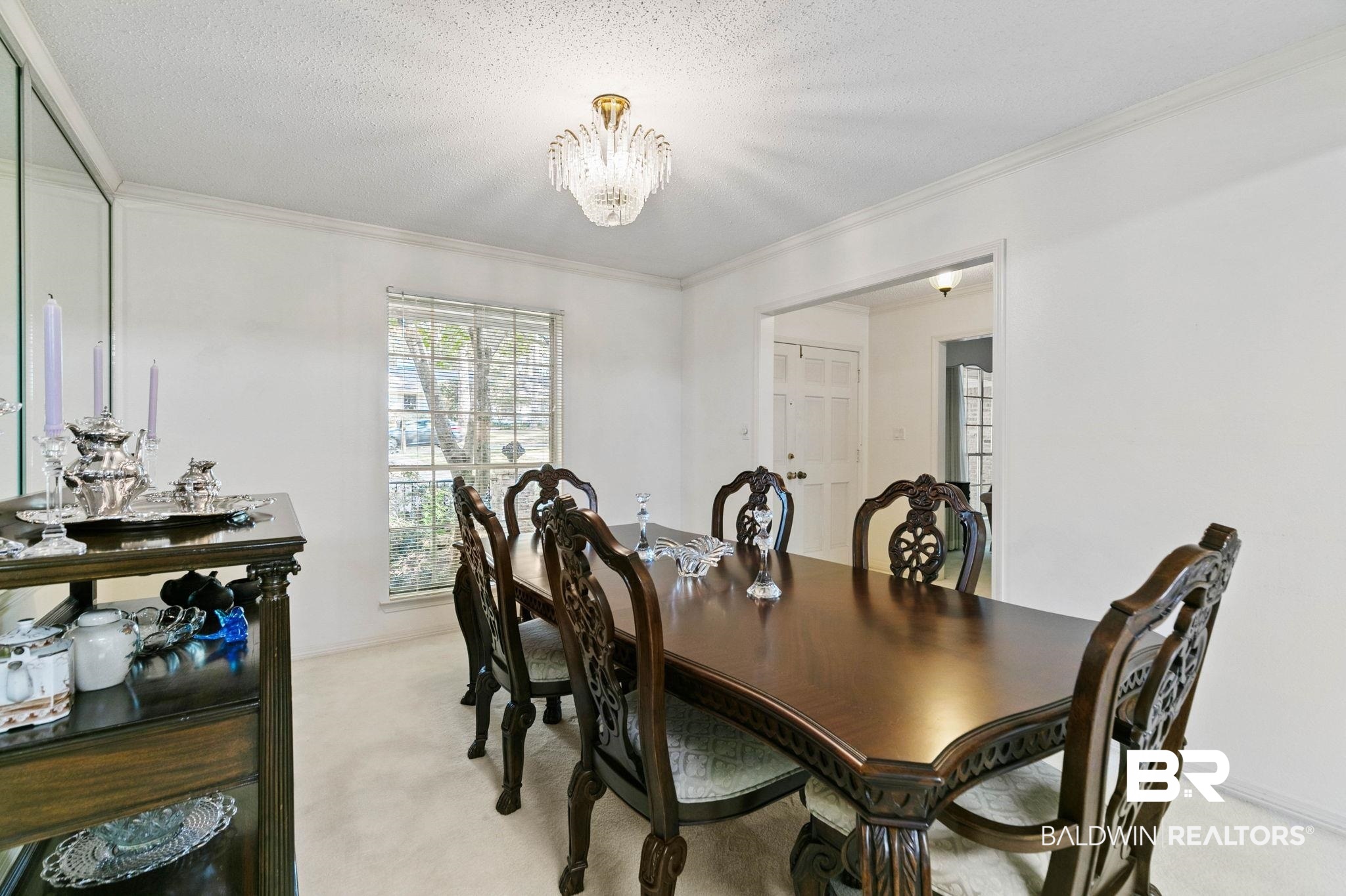 752 Evergreen Street Fairhope, AL 36532 - Photo 17 of 100 Dining room featuring ornamental molding, light carpet, a textured ceiling, and a chandelier