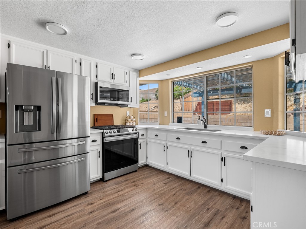 13901 Hidden Valley Road Victorville, CA 92395 - Photo 11 of 31 a kitchen with granite countertop a refrigerator stove top oven and sink