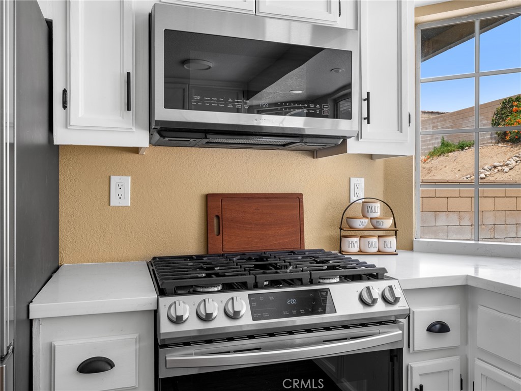 13901 Hidden Valley Road Victorville, CA 92395 - Photo 12 of 31 a stove top oven sitting inside of a kitchen