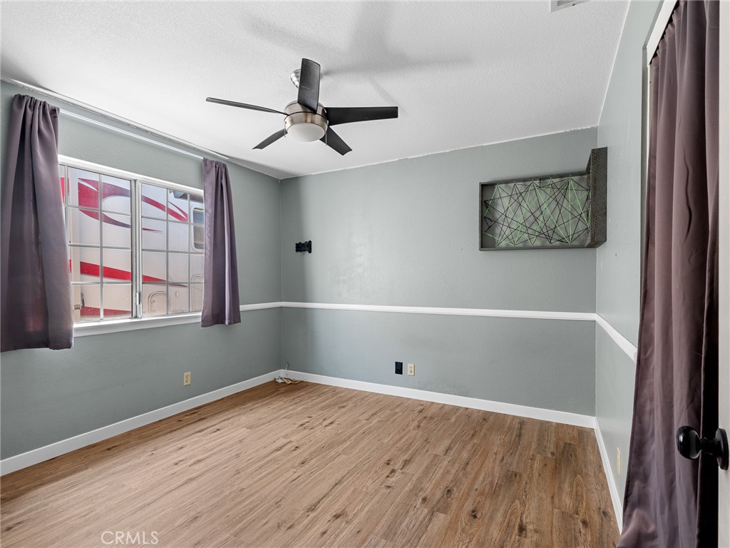 13901 Hidden Valley Road Victorville, CA 92395 - Photo 22 of 31 wooden floor in an empty room with a window