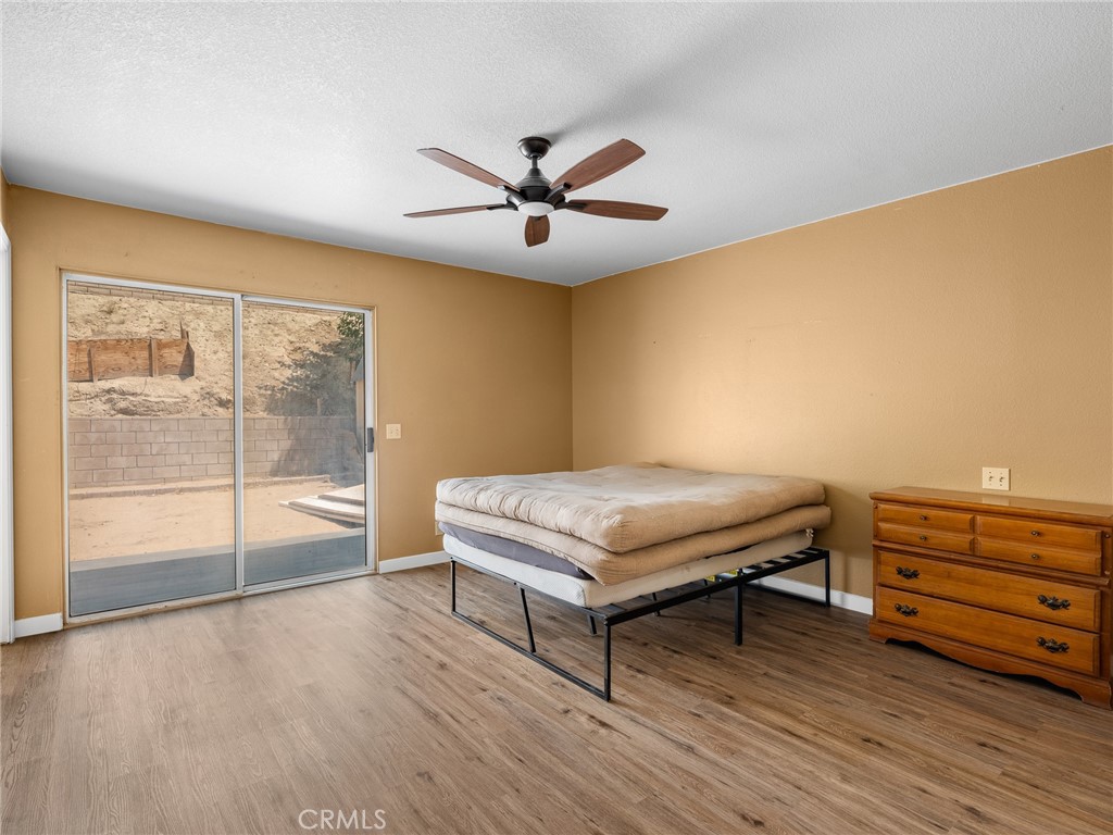 13901 Hidden Valley Road Victorville, CA 92395 - Photo 23 of 31 a living room with hard wood floors and a ceiling fan