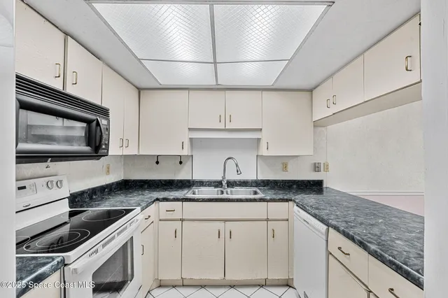 a kitchen with stainless steel appliances granite countertop a sink a stove a microwave a counter top space and cabinets