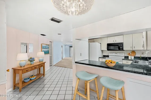 a kitchen with white cabinets and refrigerator