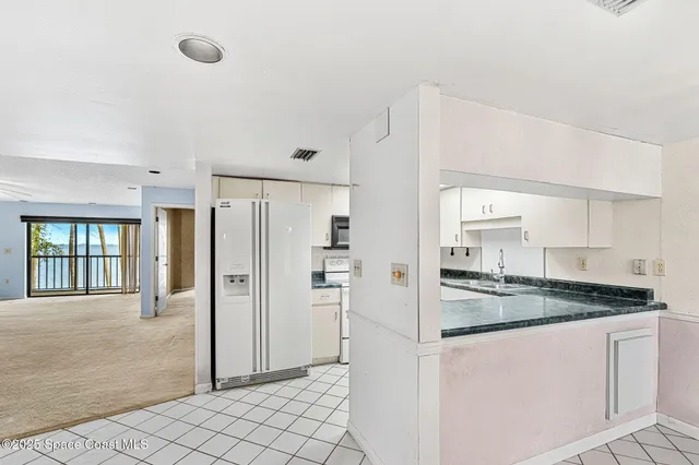 a kitchen with granite countertop white cabinets and white appliances