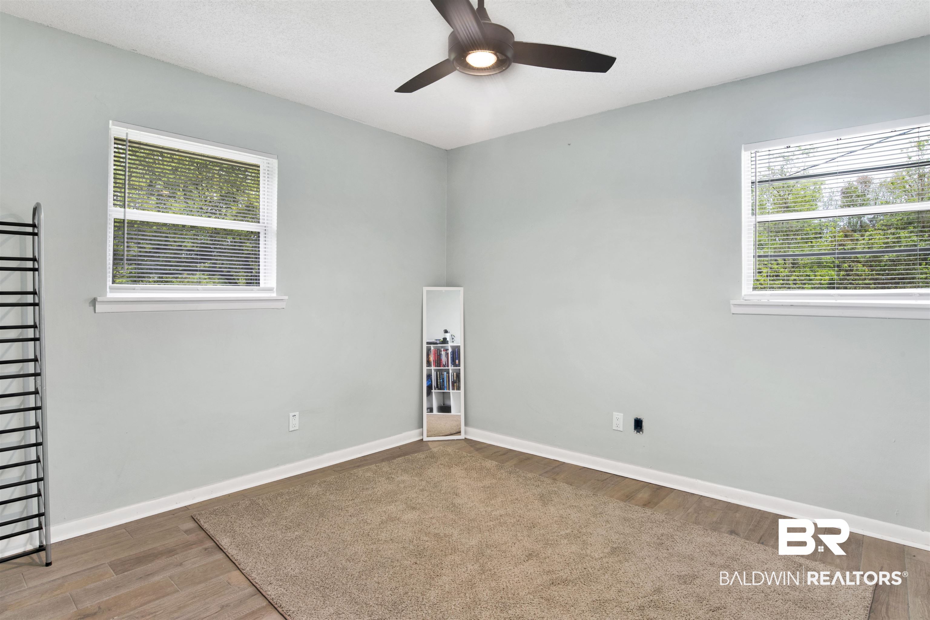 10244 Magnolia Road Irvington, AL 36544 - Photo 12 of 37 Empty room featuring a wealth of natural light, wood finished floors, and a ceiling fan