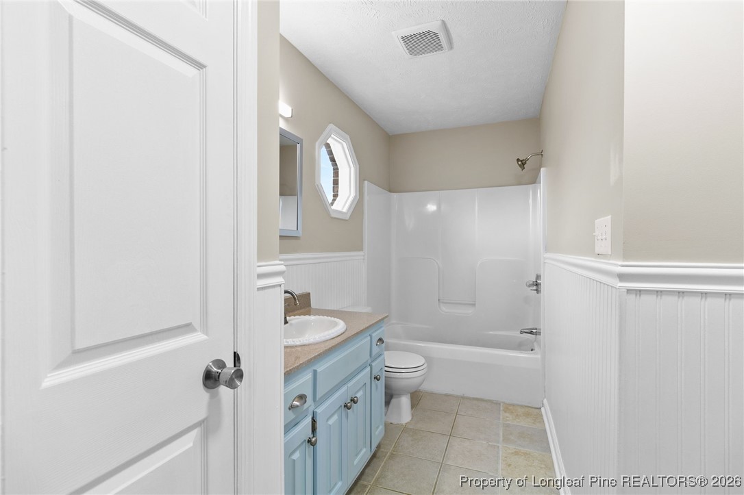 122 Spring Valley Drive Raeford, NC 28376 - Photo 18 of 36 a bathroom with a granite countertop sink a toilet and shower