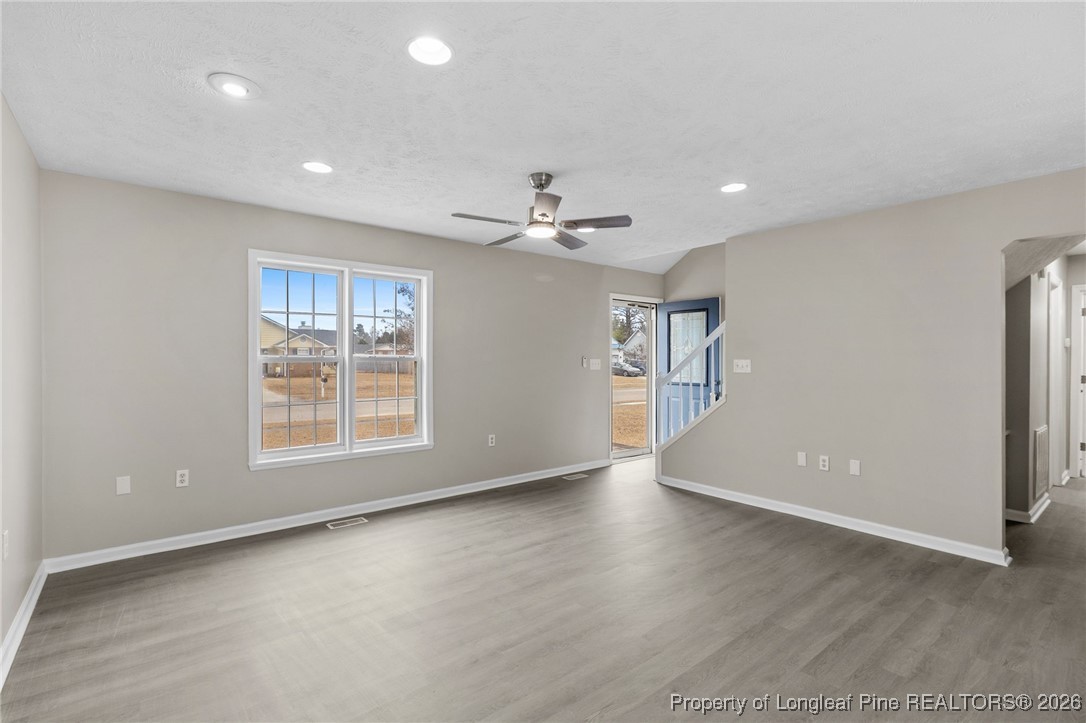 122 Spring Valley Drive Raeford, NC 28376 - Photo 7 of 36 an empty room with wooden floor and windows