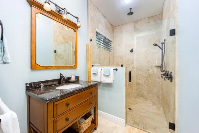 a bathroom with a granite countertop sink toilet and shower