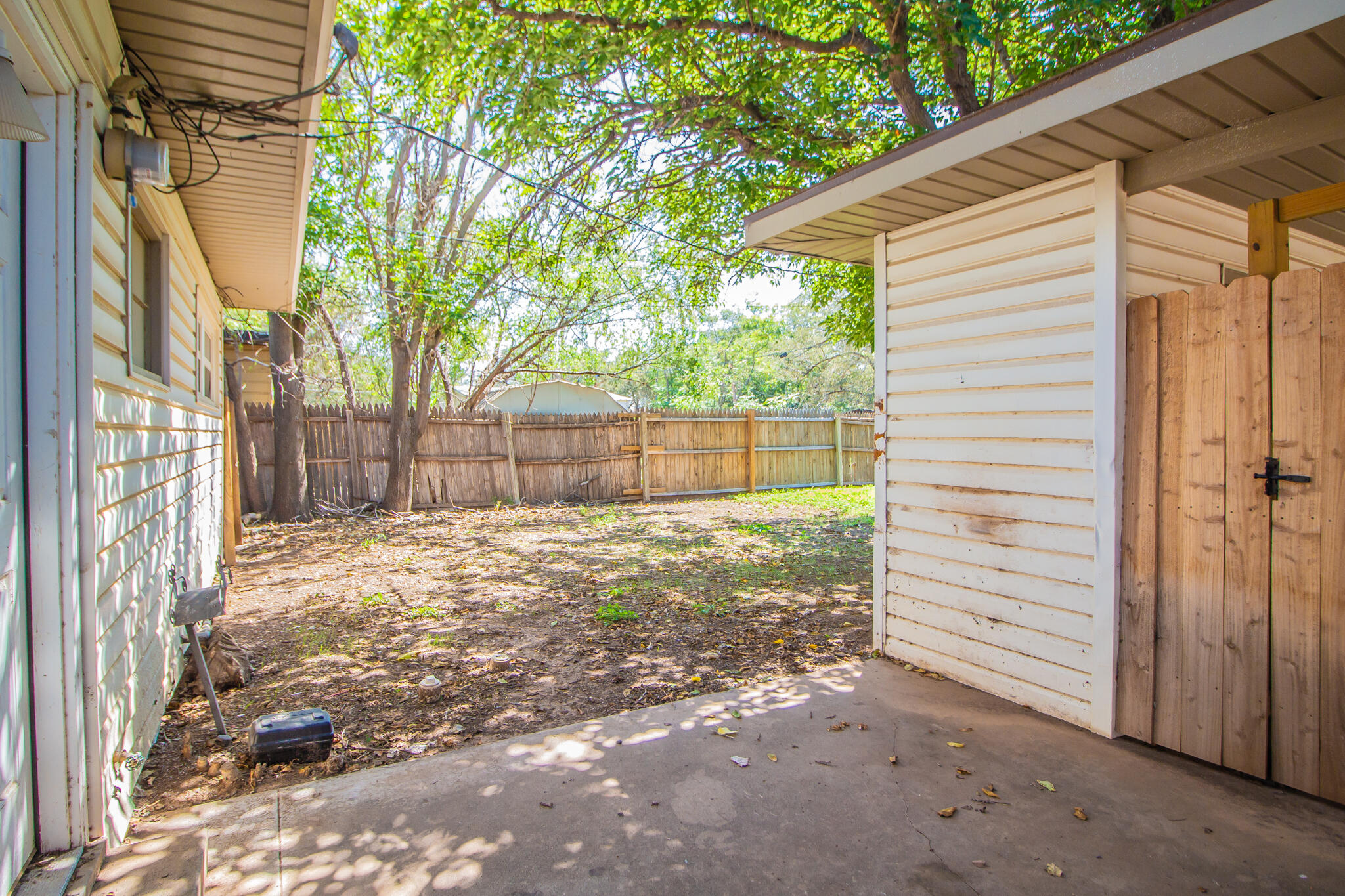 3721 31st Street Lubbock, TX 79410 - Photo 18 of 21 a view of a backyard with a large tree and wooden fence