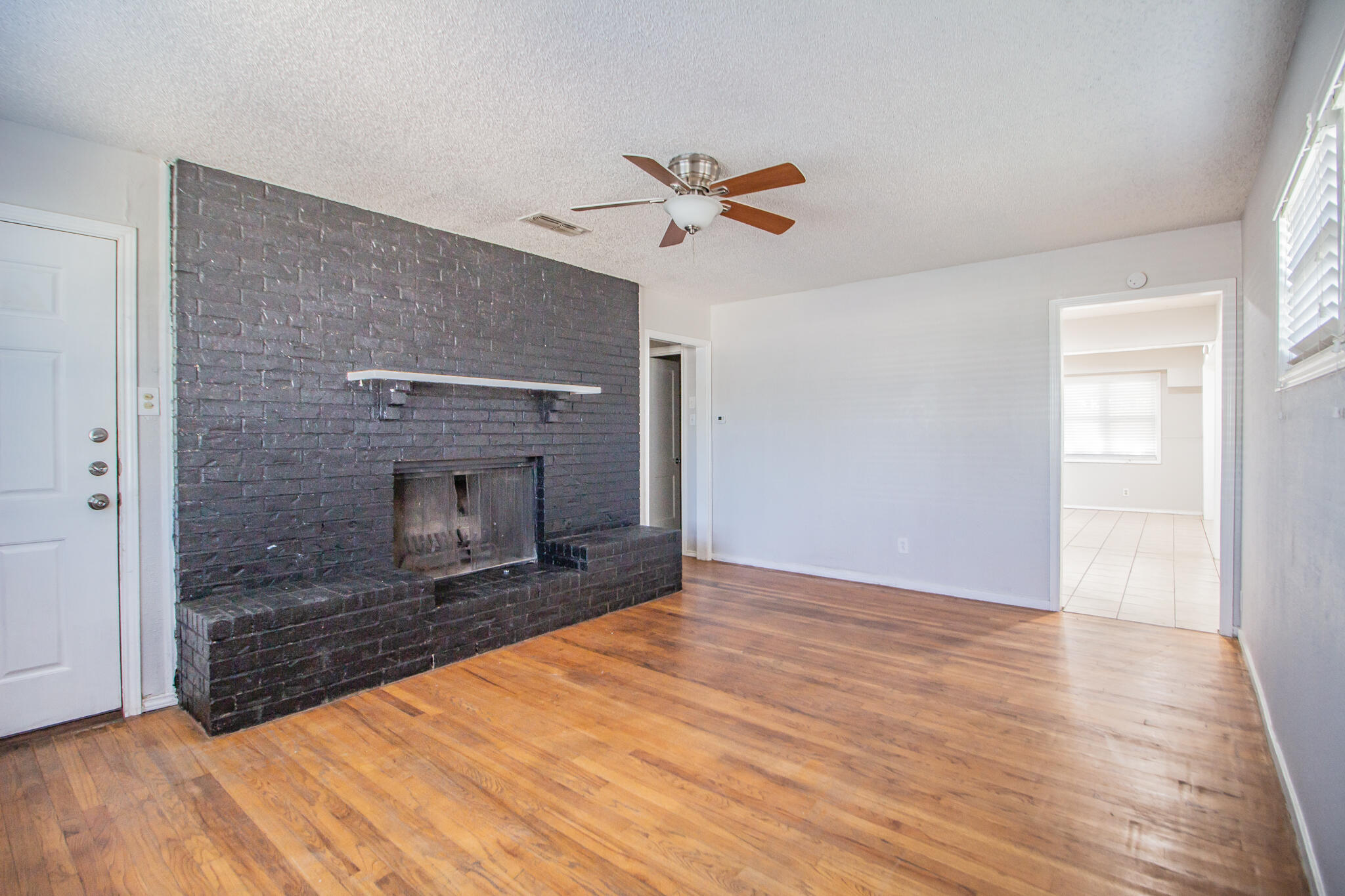 3721 31st Street Lubbock, TX 79410 - Photo 4 of 21 a view of empty room with wooden floor and fireplace