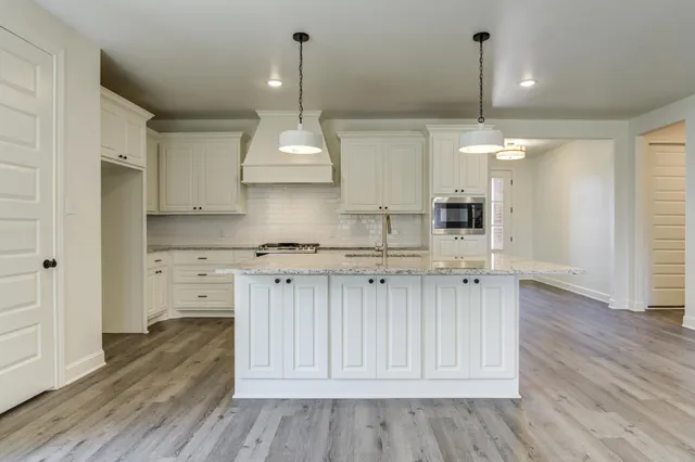 a view of kitchen with granite countertop cabinets and wooden floor