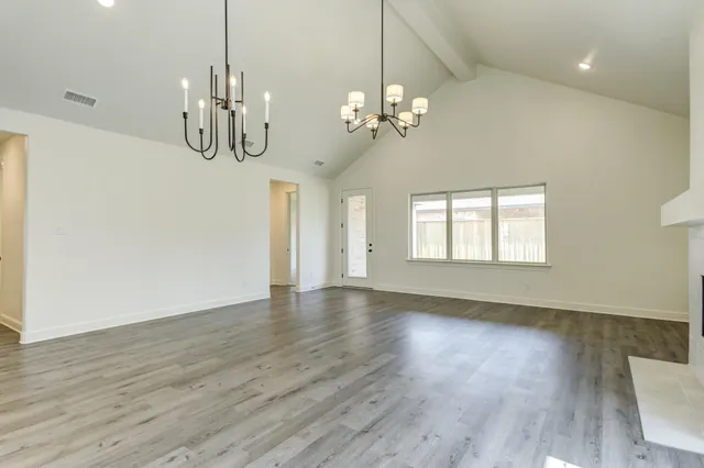 a view of a room with wooden floors and chandelier