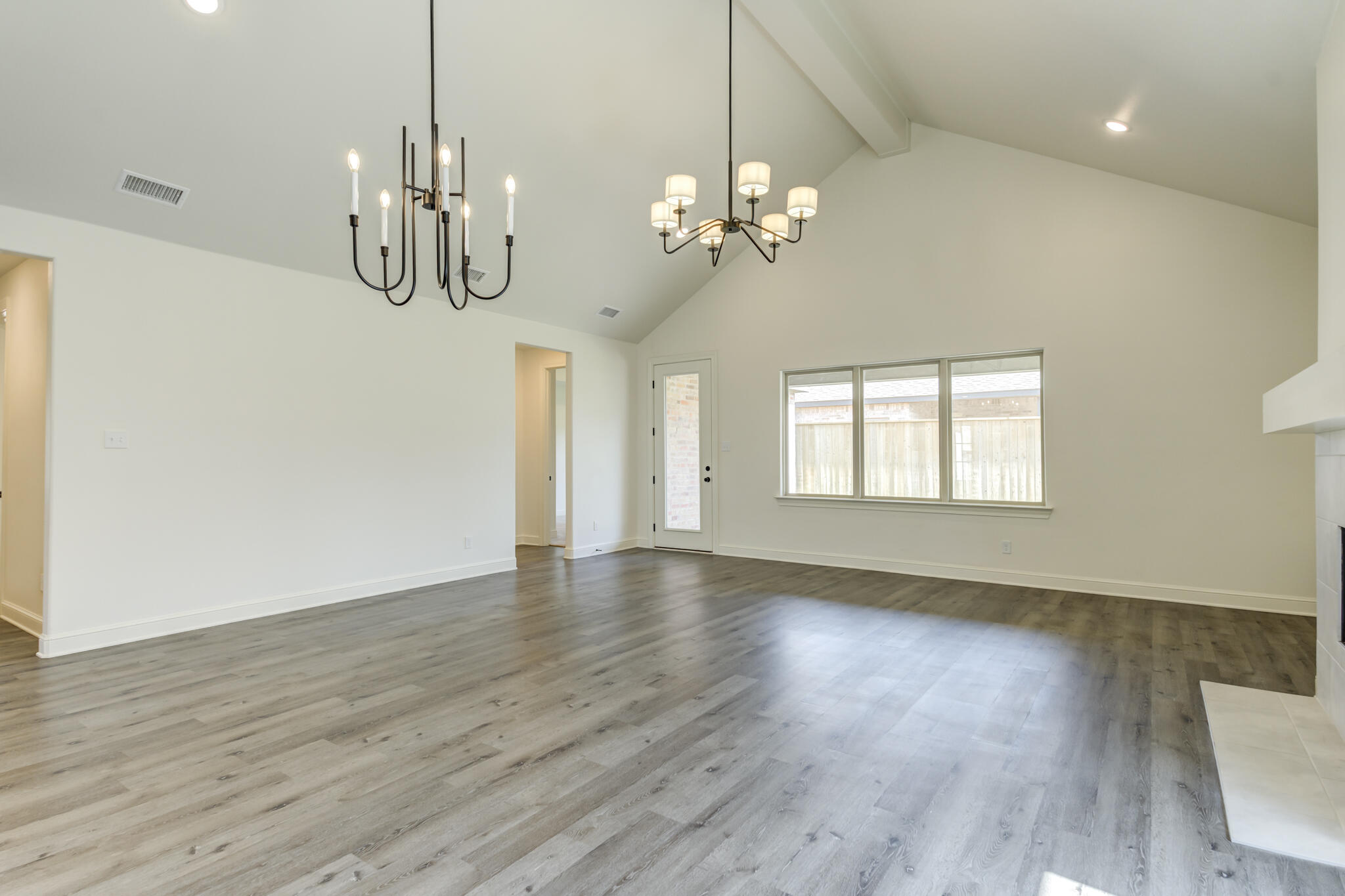 6904 55th Street Lubbock, TX 79407 - Photo 16 of 47 a view of a room with wooden floors and chandelier