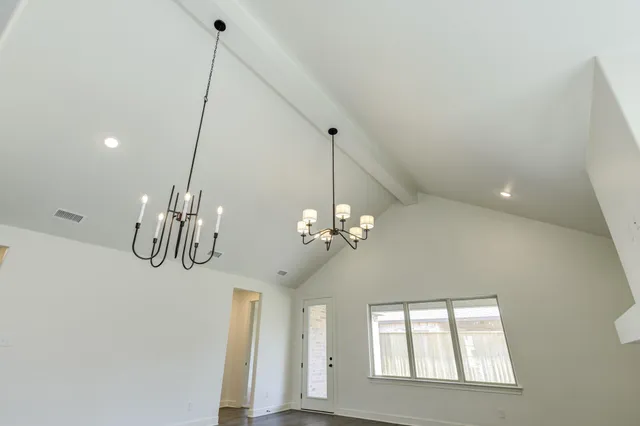 a view of a room with chandelier fan and windows